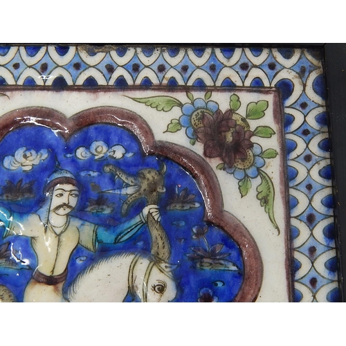 324 - Qajar moulded polychrome pottery tile.
Moulded and painted in underglaze blue, green & mauve depicti... 