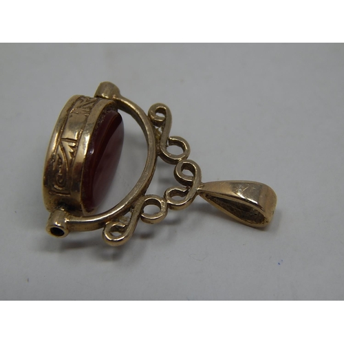 277 - 9ct gold onyx and carnelian spinner pendant. 591474