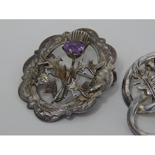 91 - 2 x Scottish Silver Brooches set with amethyst coloured stones.