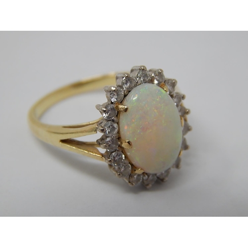 43 - 14ct Gold Ring Set with a Central Opal Estimated at 3.00cts within a Border of 18 Diamonds: Ring Siz... 
