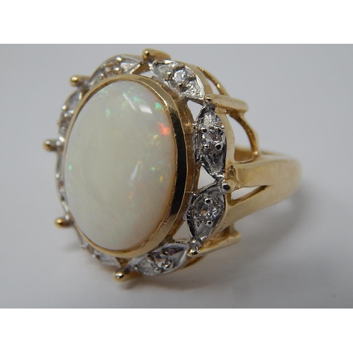 45 - HUGE Opal Ring Set with a Central Opal Measuring 16mm x 12mm within a Diamond Border Mounted in 9ct ... 