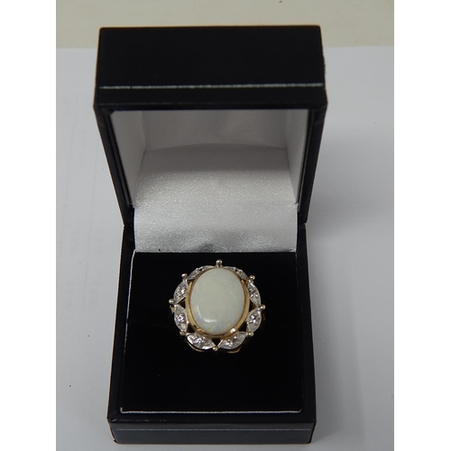 45 - HUGE Opal Ring Set with a Central Opal Measuring 16mm x 12mm within a Diamond Border Mounted in 9ct ... 