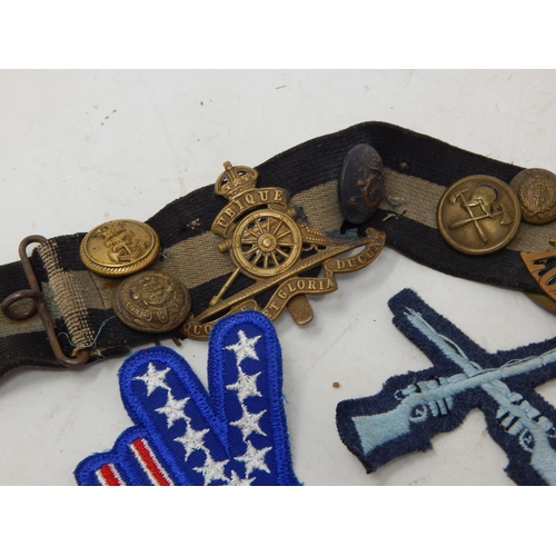 565 - Snake Belt with attached Military Badges & Buttons together with a further quantity of Military Badg... 