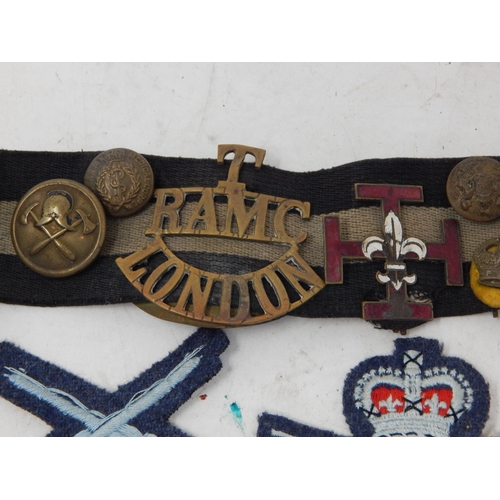 565 - Snake Belt with attached Military Badges & Buttons together with a further quantity of Military Badg... 