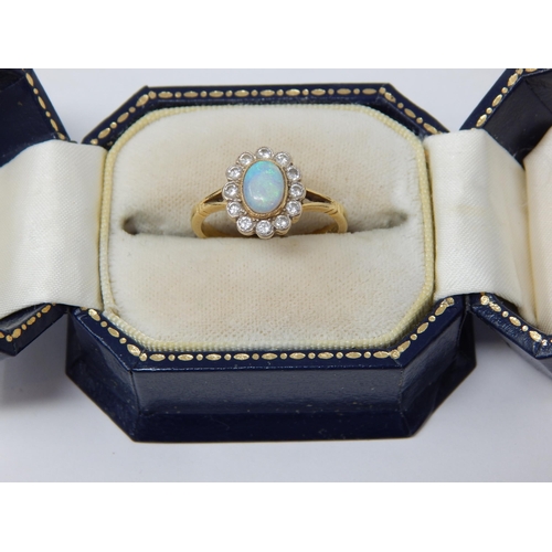 295 - 18ct Yellow Gold Ring Set with a Central Opal within a Border of 12 Diamonds: Ring Size P: Gross wei... 