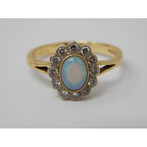 295 - 18ct Yellow Gold Ring Set with a Central Opal within a Border of 12 Diamonds: Ring Size P: Gross wei... 