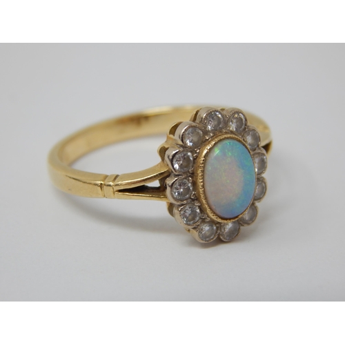 295 - 18ct Yellow Gold Ring Set with a Central Opal within a Border of 12 Diamonds: Ring Size P: Gross wei... 