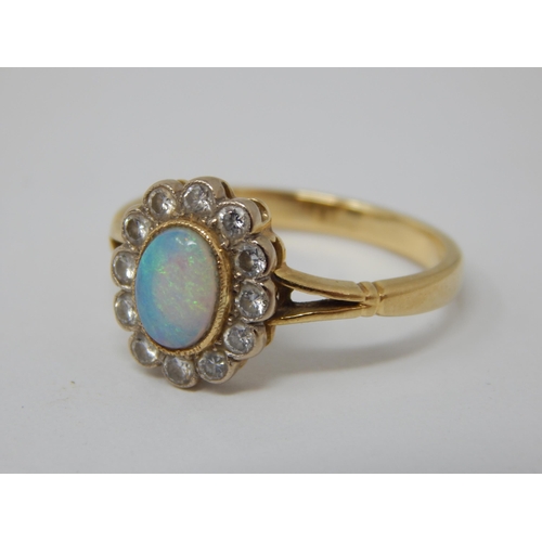 295 - 18ct Yellow Gold Ring Set with a Central Opal within a Border of 12 Diamonds: Ring Size P: Gross wei... 