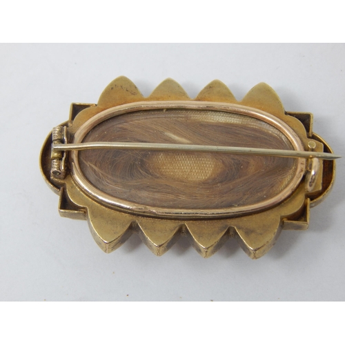 78 - A Victorian Yellow Metal Mourning Brooch with reverse Hair Panel: 4cm wide: Gross weight 11.16g