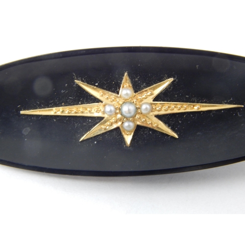 79 - A Victorian Jet Mourning Brooch with a Gold Mounted Star Set with Seed Pearls: 5cm wide