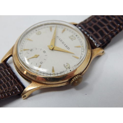 169 - GARRARD: Gentleman's 9ct Gold Wristwatch with subsidiary seconds dial on brown leather strap. Workin... 