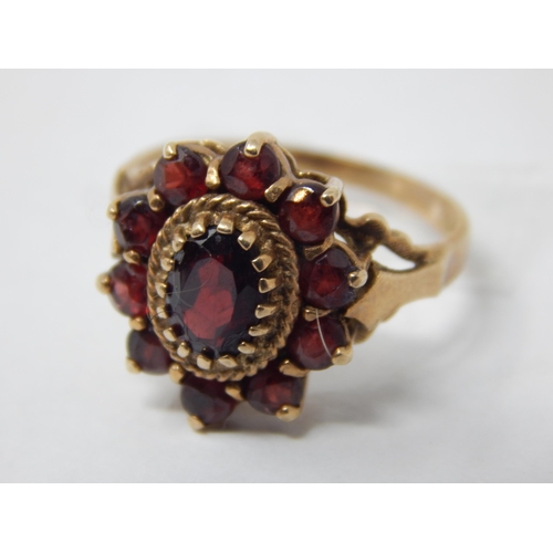 212 - 9ct Yellow Gold Ring Set with a Central Garnet within a Border of Garnets: Size M: Gross weight 3.44... 