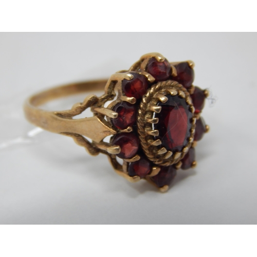 212 - 9ct Yellow Gold Ring Set with a Central Garnet within a Border of Garnets: Size M: Gross weight 3.44... 