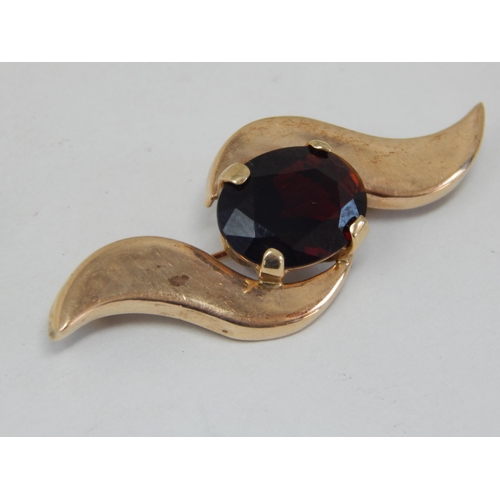 252 - 9ct Gold (tested) Brooch set with a central garnet: Width 5.4cm: gross weight 8.78g