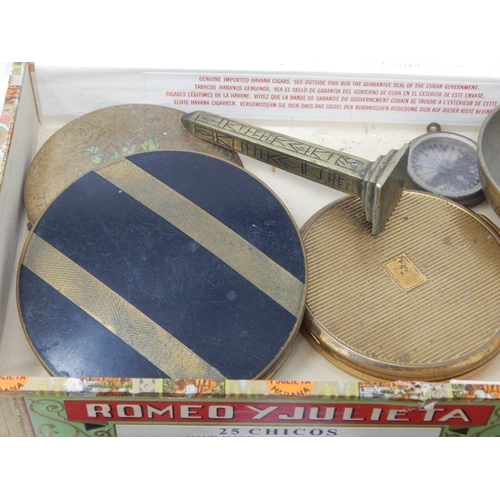 390 - A Cigar Box Containing Brass Figural Plaques, Shoe Buckles, Compacts, Compass, Pestle & Mortar etc