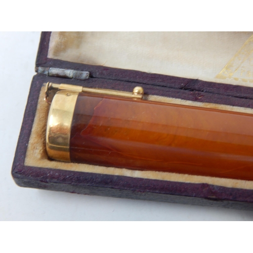 107 - Two Gold Mounted Amber Cigarette Holders together with a further cigarette holder in original fitted... 