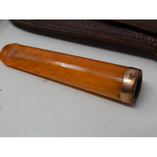 107 - Two Gold Mounted Amber Cigarette Holders together with a further cigarette holder in original fitted... 