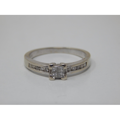 158 - 9ct White Gold Diamond Ring with a Central Panel Containing Four Princess Cut Diamonds: The Shoulder... 