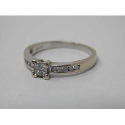 158 - 9ct White Gold Diamond Ring with a Central Panel Containing Four Princess Cut Diamonds: The Shoulder... 