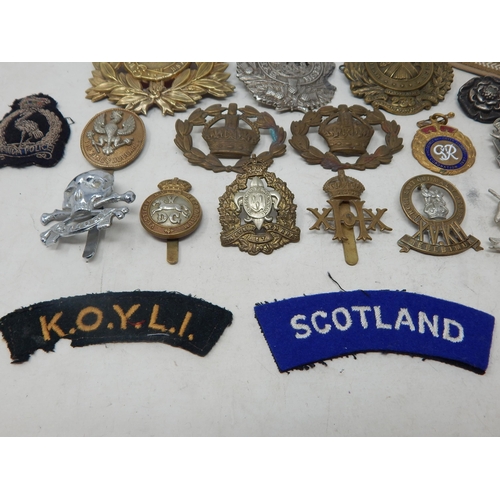 441 - A Quantity of Military Brass & White Metal Badges together with cloth badges & insignia.