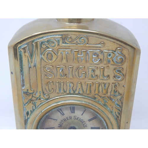 301 - MOTHER SEIGELS CURATIVE ADVERTISING CLOCK. 7.8ins tall, heavily embossed brass body in the shape of ... 