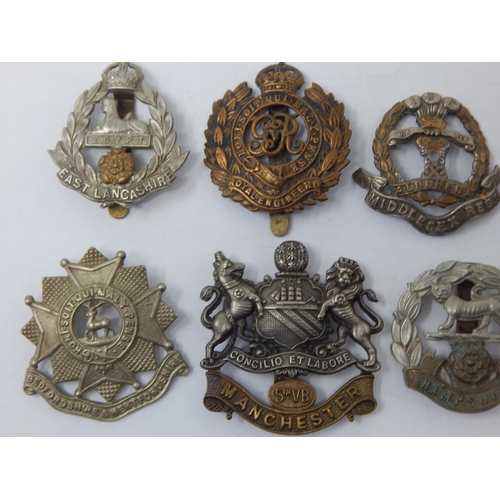 85 - Collection of Military Badges to Include: East Lancashire, Suffolk Regiment, Manchester, Hampshire, ... 