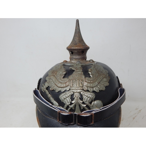 204 - A WWI Imperial German Army pickelhaube uniform helmet with cover. Leather construction with brass fr... 