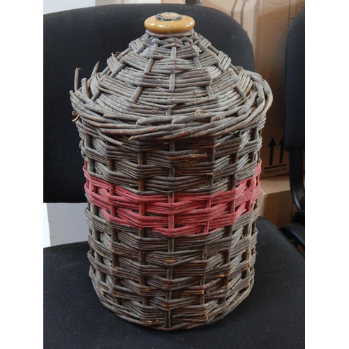 An Empty Royal Naval Stoneware Rum Flagon in Wicker Casing.