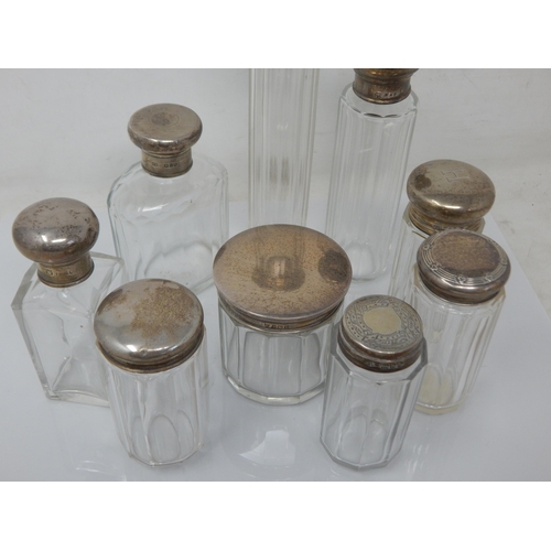 119 - A Collection of 9 Hallmarked Silver Topped Dressing Table Jars: Various Dates & Makers.