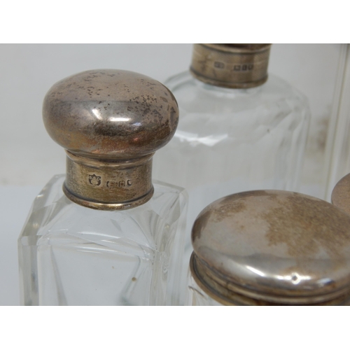 119 - A Collection of 9 Hallmarked Silver Topped Dressing Table Jars: Various Dates & Makers.