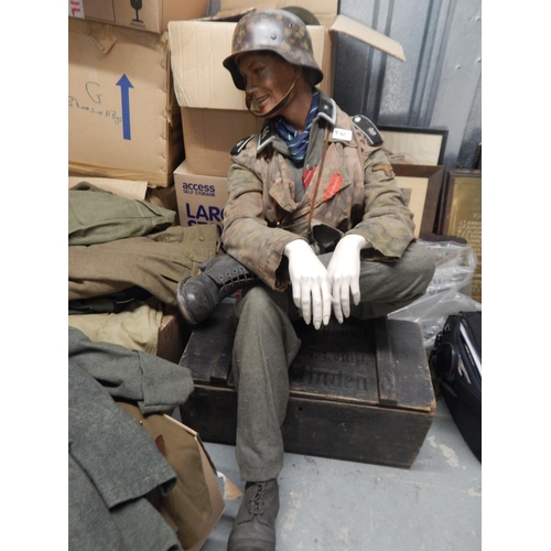 WWII German Uniform helmet, gun holster, binoculars, boots etc displayed on a seated manakin. All believed original clothing and helmet. The helmet with a replacement liner.