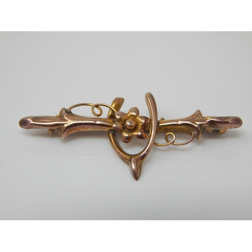 135 - Victorian unmarked yellow metal horseshoe and floral bar brooch - 1.1g gross