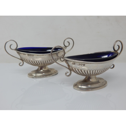 151 - A pair of Victorian silver blue-glass lined navette salts with scroll handles and gadroon bases – Ro... 