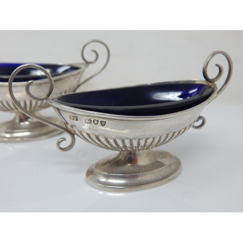 151 - A pair of Victorian silver blue-glass lined navette salts with scroll handles and gadroon bases – Ro... 