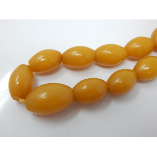 97 - 9ct Gold Clasped Amber Bead Necklace: Length 64cm: Weight 38g