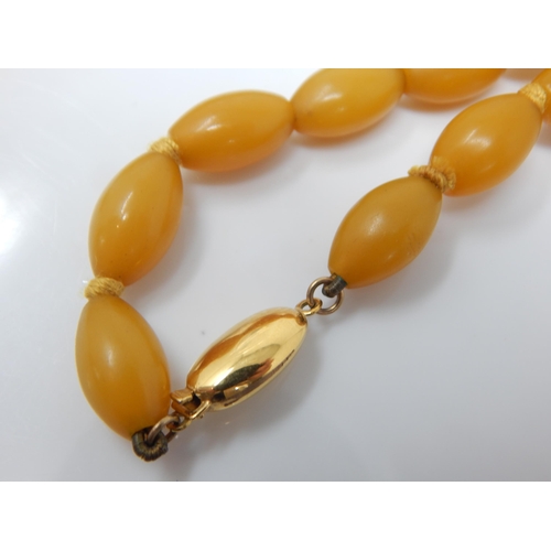 97 - 9ct Gold Clasped Amber Bead Necklace: Length 64cm: Weight 38g