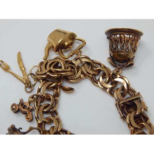 340 - 9ct Gold Charm Bracelet with Numerous Charms: Weight 65.61g