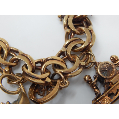 340 - 9ct Gold Charm Bracelet with Numerous Charms: Weight 65.61g
