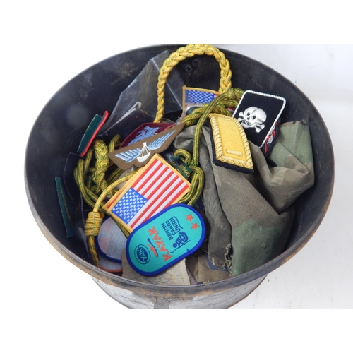 338 - A Military Tin Hat Box containing a quantity of cloth badges.