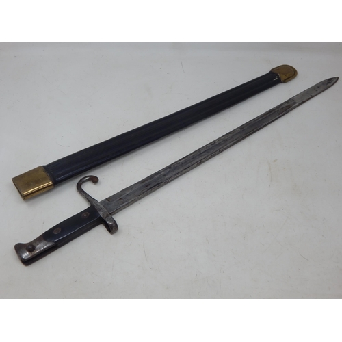 307J - WWI Caricano Bayonet with brass mounted leather scabbard. Overall length 66cm