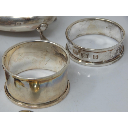 66 - A children's silver rattle, group of hallmarked Silver napkin rings, etc total weight 189.43g.