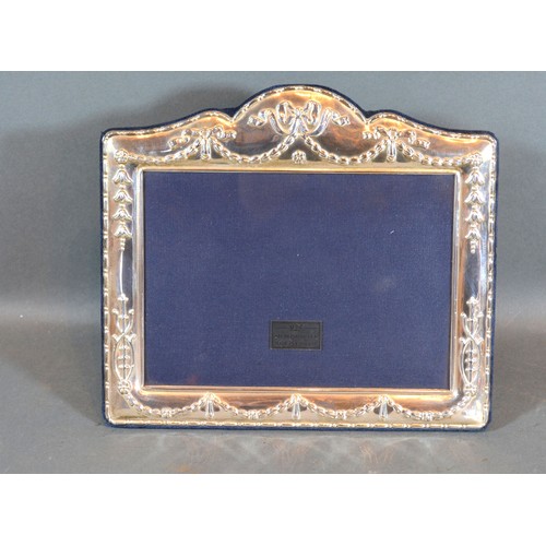 158 - A Sterling Silver Photograph Frame Embossed Bows and Swags, 19 x 22 cms