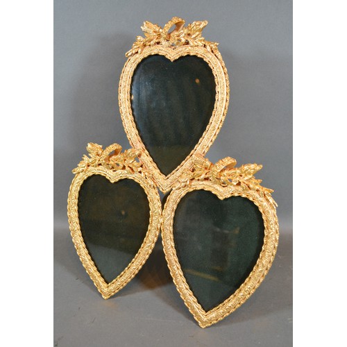 377 - A Gilt Metal Triple Photograph Frame of heart form with torch and quiver cresting 25cm by 31cm tall