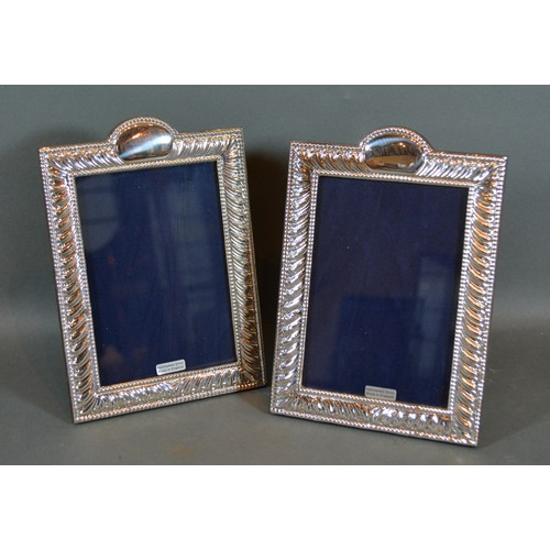 234 - A Pair of Sterling Silver rectangular Photograph Frames with embossed decoration 20cm by 13.5cm