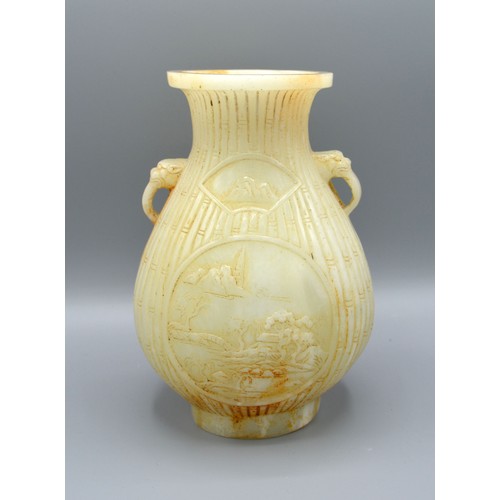 386 - A Chinese Jade Vase carved with two reserves amongst bamboo and with foe head side handles, 19 cms t... 