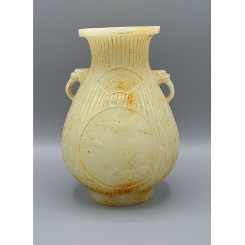 386 - A Chinese Jade Vase carved with two reserves amongst bamboo and with foe head side handles, 19 cms t... 