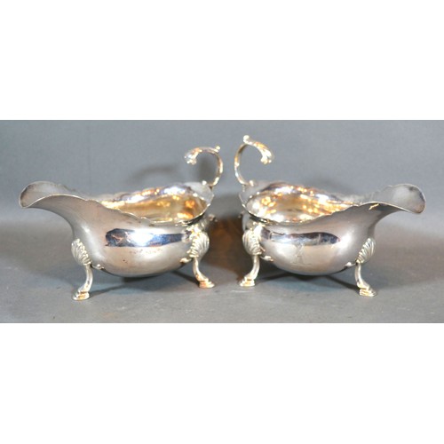 208 - A Pair of George III Silver Sauce Jugs with shaped scroll handles and hoof supports, London 1761, ma... 