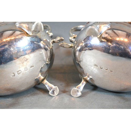 208 - A Pair of George III Silver Sauce Jugs with shaped scroll handles and hoof supports, London 1761, ma... 