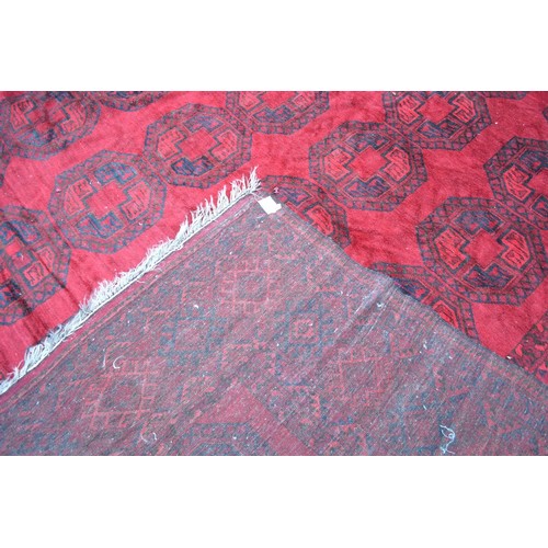 428 - A Bokhara Woollen Carpet with four rows of guls upon a red and blue ground within multiple borders 4... 