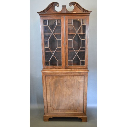 399 - A 19th Century Mahogany Bookcase with a swan neck pediment above two astragal glazed doors enclosing... 